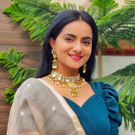 A lady wearing astha kundan necklace set
