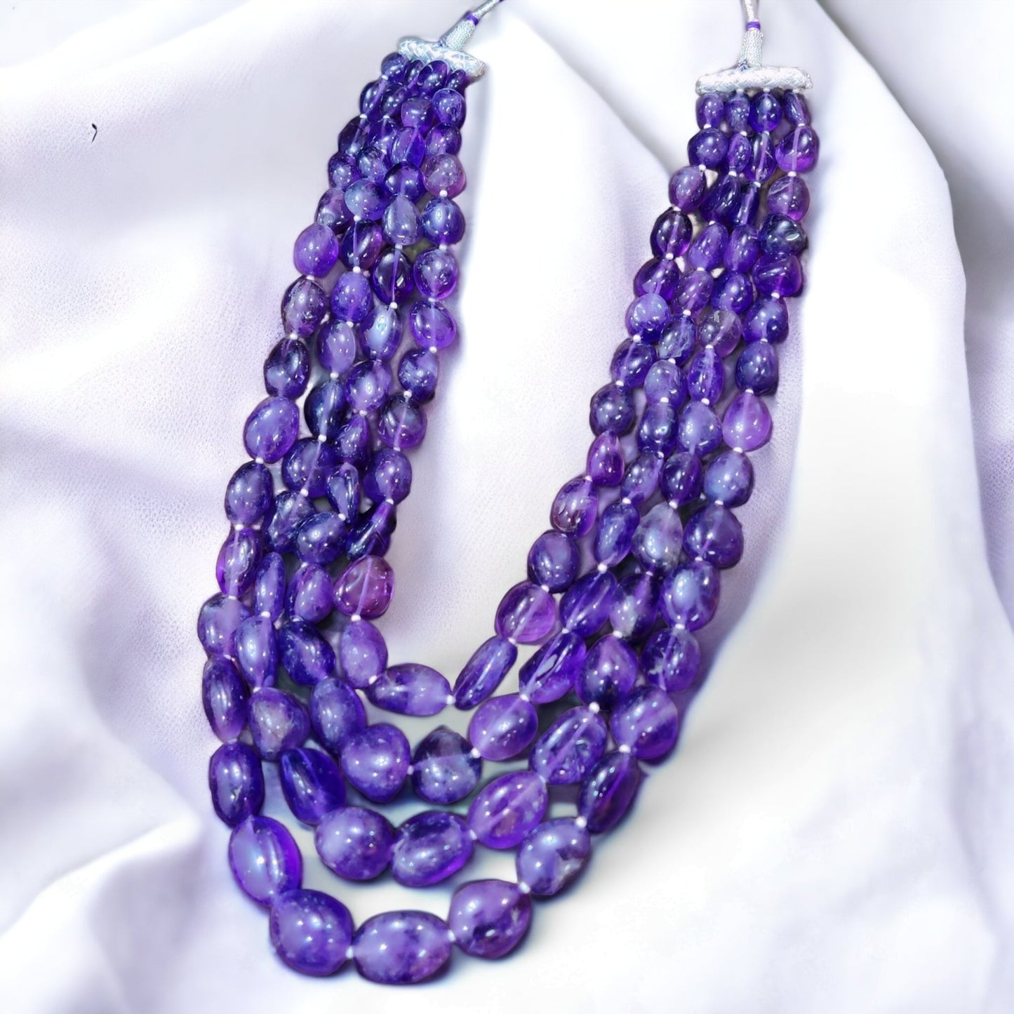 Blue-violet natural tanzanite gemstone amethyst mala on the white background