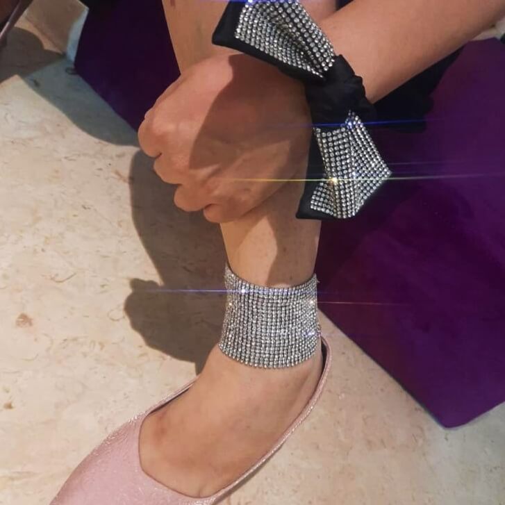 A lady wearing a zirconia anklet and bracelet