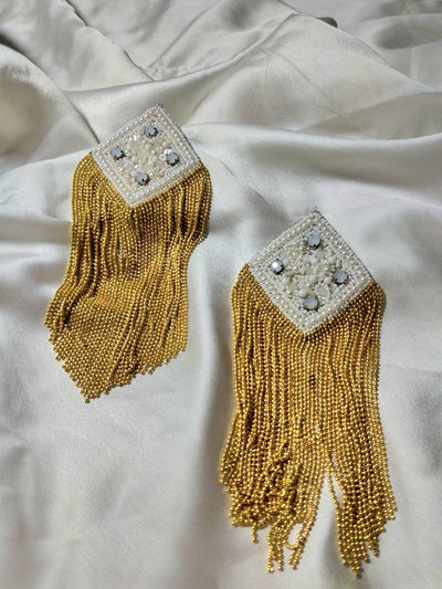 Golden long tassel earrings on white background