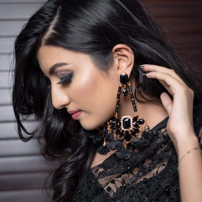 A lady wearing a floral jhoomer earring in black color