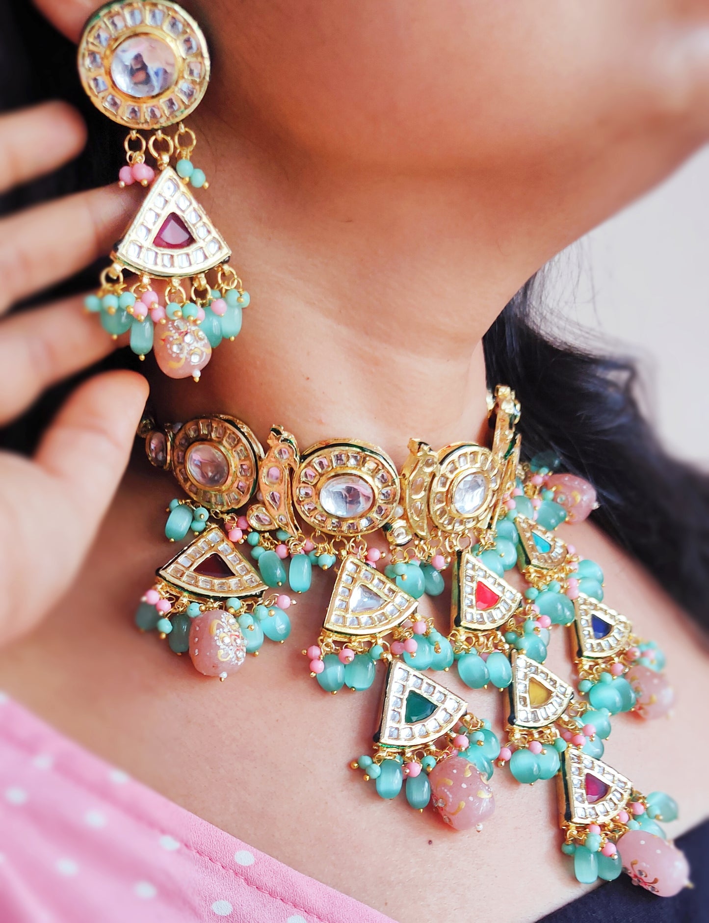 A lady wears a kanika navratan layered necklace and earring